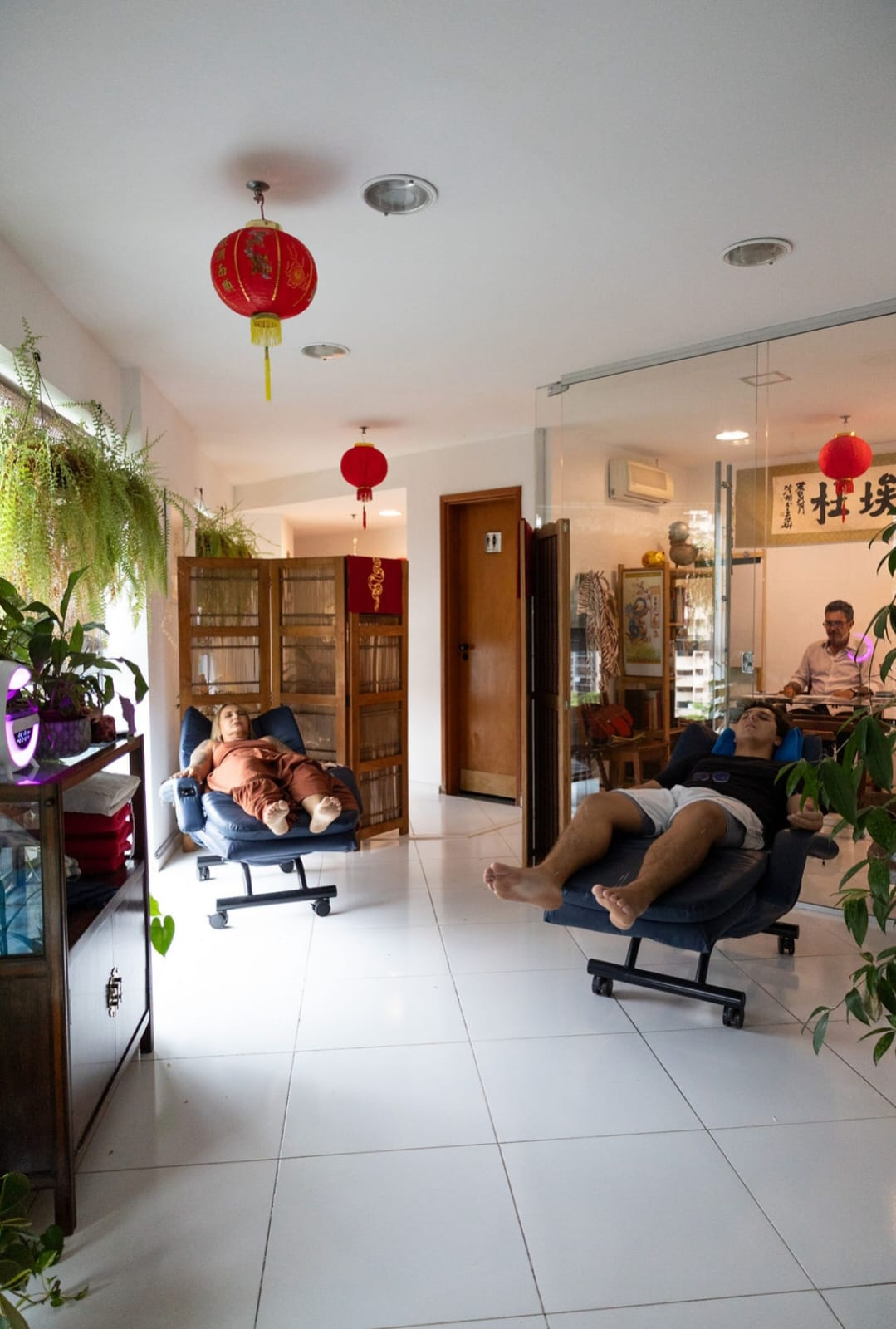 Espaço de atendimento da Clínica Tung com ambiente acolhedor e pacientes em repouso.